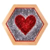 Hexagonal wooden frame housing a red sequin heart on a silver glitter background (decorative art).