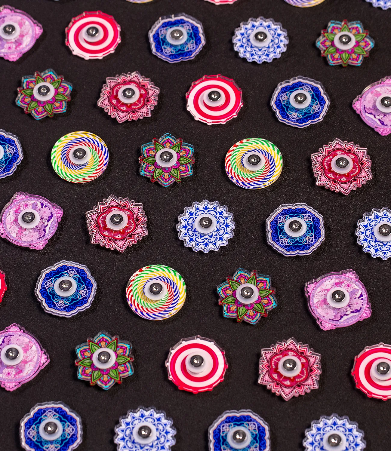 fidget-spinner-small-4 | LiteZilla Assorted colorful mandala-style circular buttons arranged on a black background.
